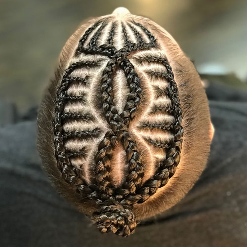 Diseño en trenzas en hombre terminando en un meoño con pelo corto a los lados